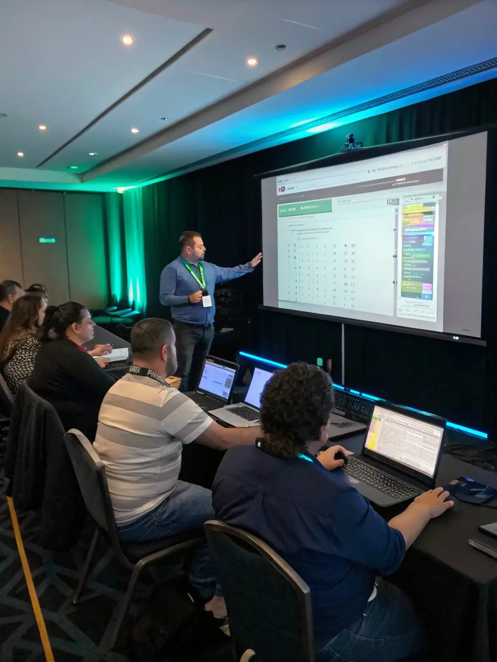 A trainer leading a training session on integrated systems, demonstrating how to operate and maintain the platform to a group of community members.
